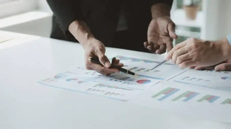 Two businessmen are brainstorming together and reviewing the company financial documents that the fi